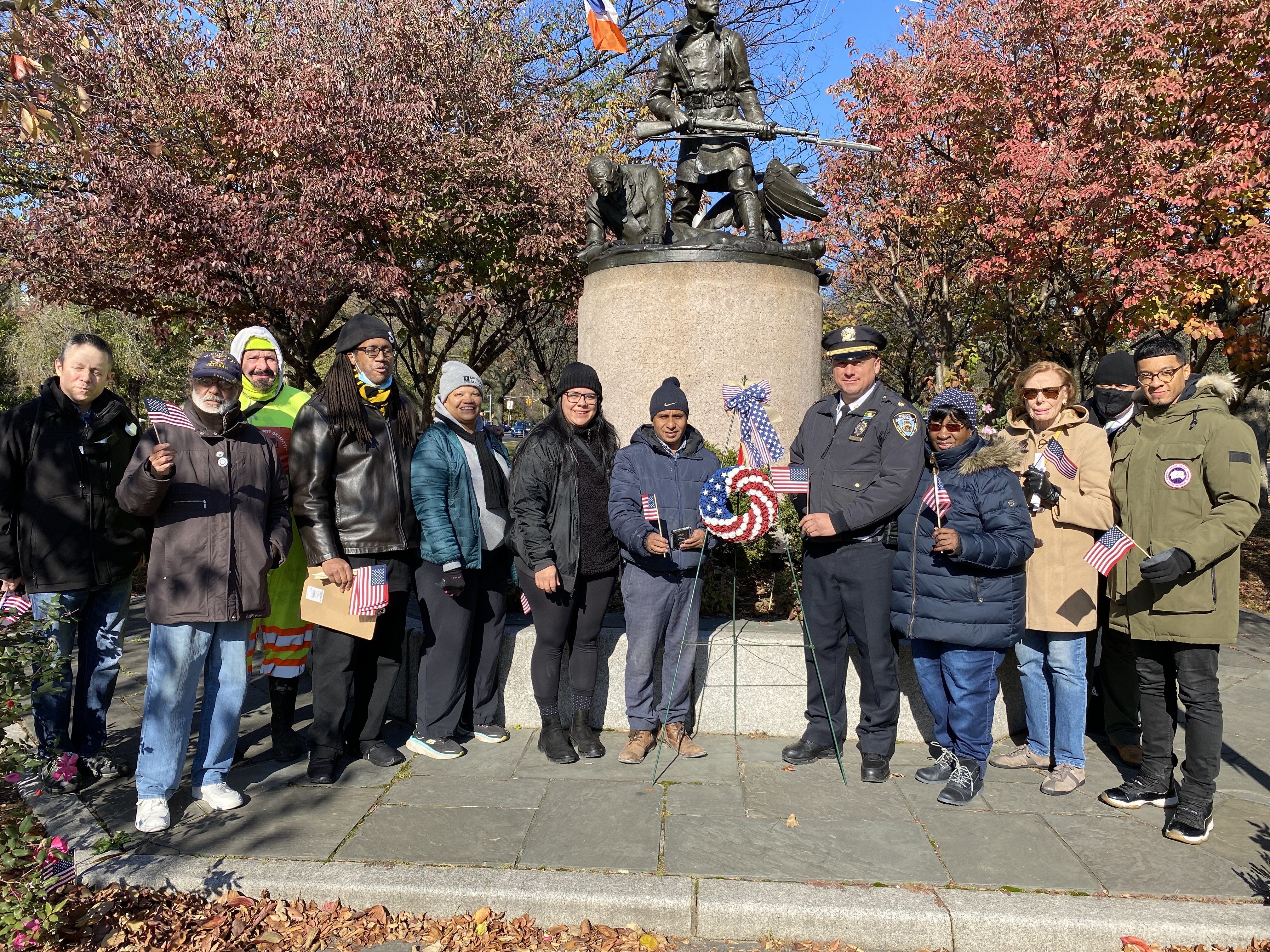 Group of BXCB7 members standing and smiling in front of statue
                                           