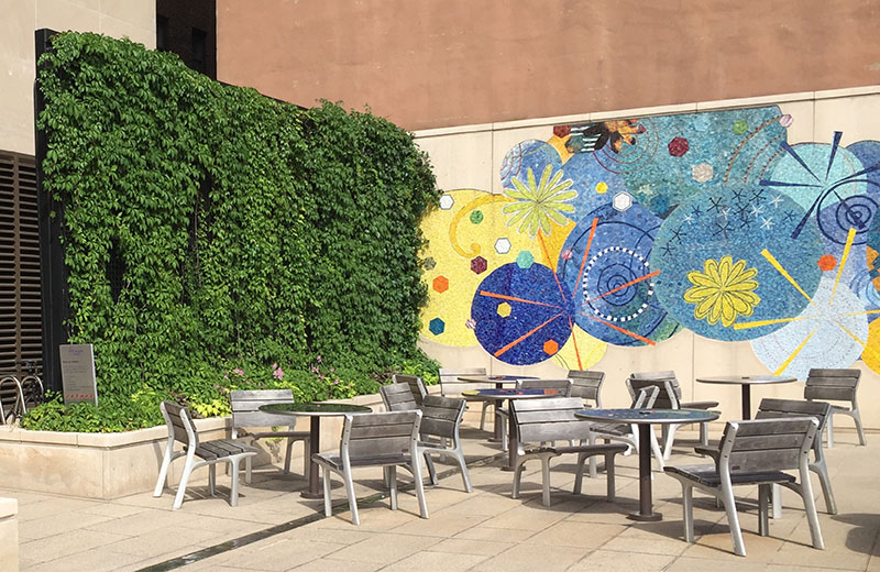Screening blank walls with planting and artwork improves attractiveness of the plaza  
