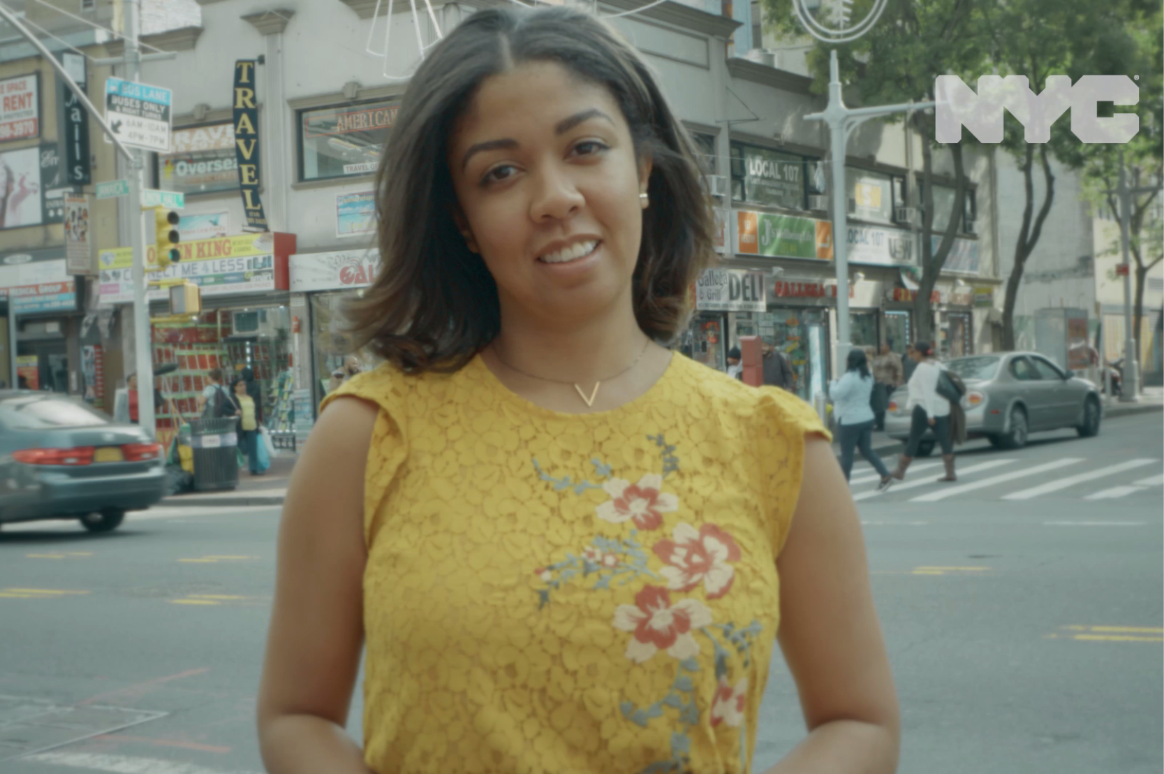 Screenshot from a video of a young woman standing at a NYC intersection.