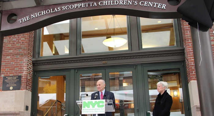 Commissioner Nicholas Scoppetta standing on a podium outside of the Nicholas Scoppetta Children's Center