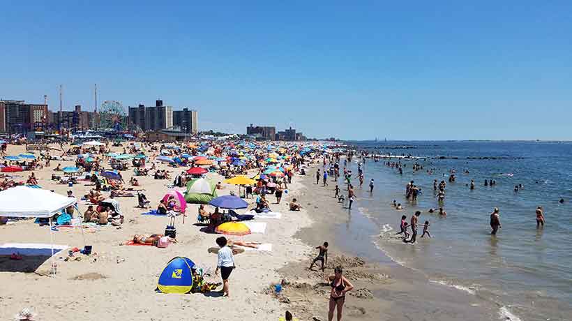 people relaxing on Coney Island Beach on a hot day in the Summer
                                           
