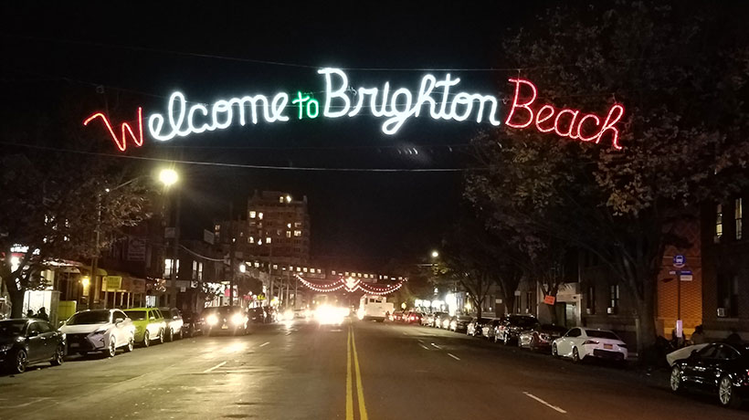 Holiday lights above street that say Welcome to Brighton Beach
                                           