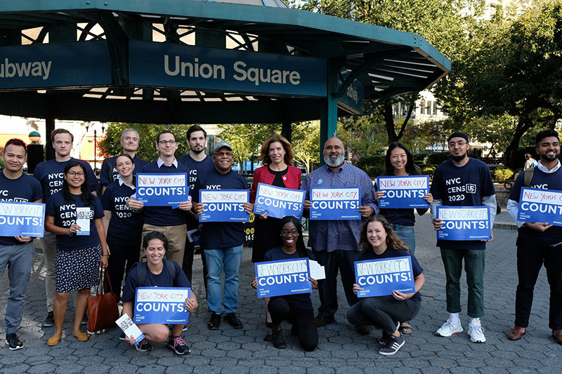 Group of volunteers standing in front of the Union Square station holding Signs