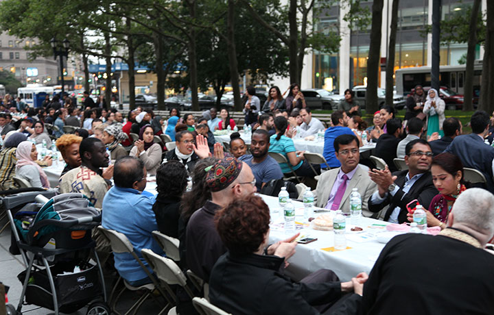 group of people sitting at table at Community Iftar in the Streets Spring 2017 l
                                           