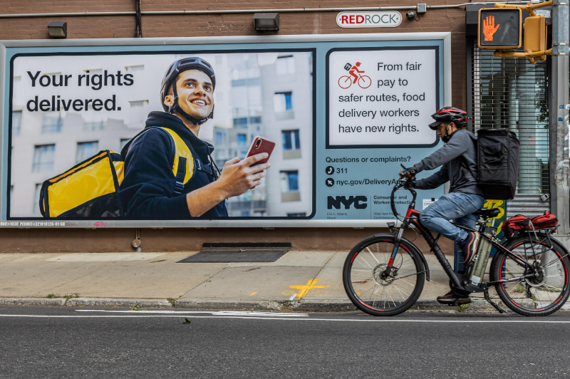 Large billboard of a food delivery worker ad, Your rights delivered.
                                           