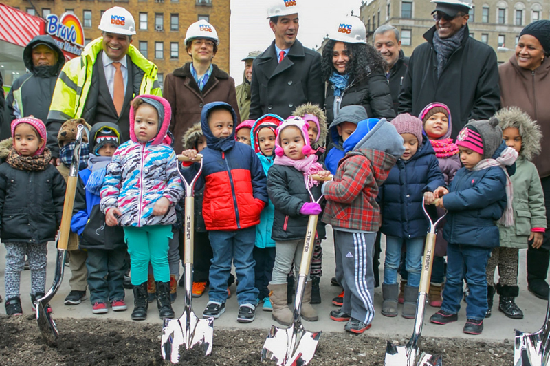 Children stand behind shovels at the ground breaking ceremony.
