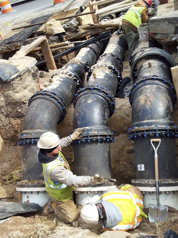 Workers install a manifold to support new water mains at Lafayette and Grand streets