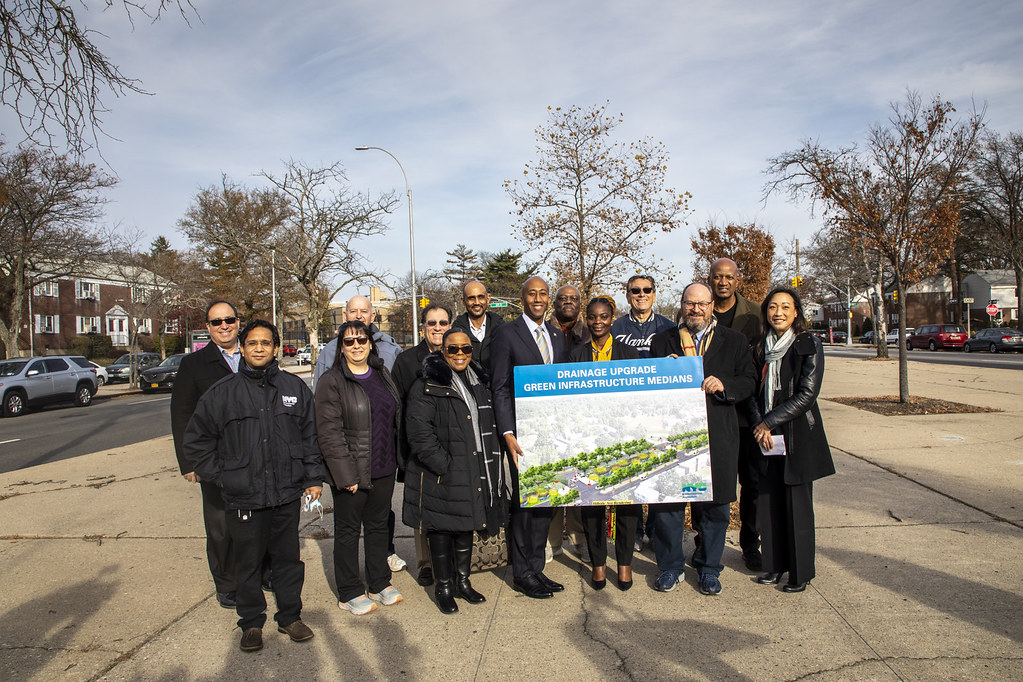 Stakeholders hold a sign at the sight of the project