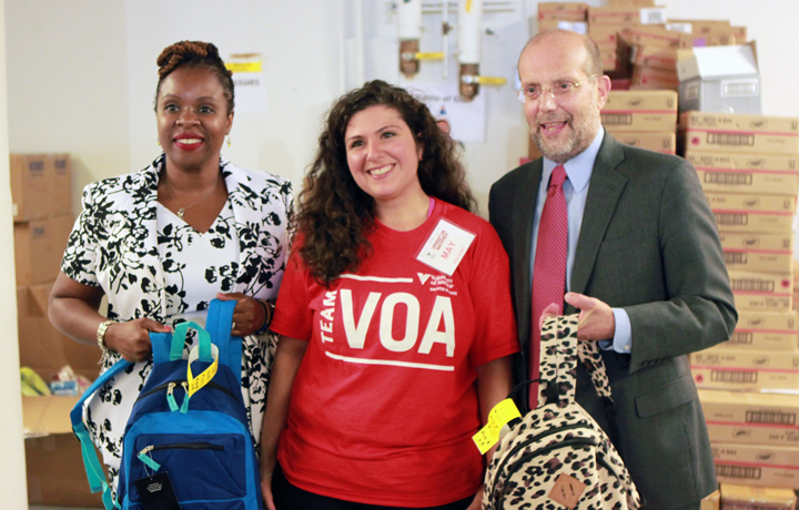DHS Administrator Carter and DSS Commissioner Banks with a VOA volunteer at the Operation Backpack Sort Space Warehouse