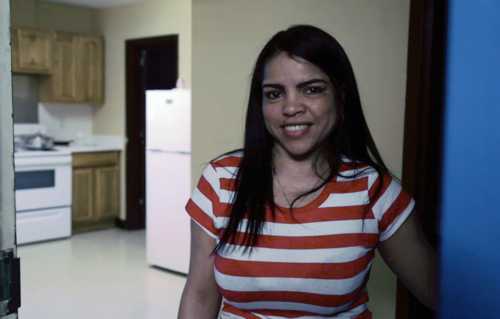 Woman standing in a kitchen smiling