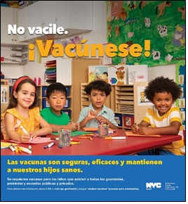 Niños, sonrientes, sentados en la mesa de un salón de clase. El texto del afiche dice: No vacile. ¡Vacúnese! Las vacunas son seguras, eficaces y mantienen a nuestros hijos sanos.