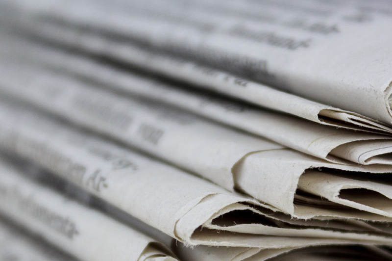 A stack of newspapers that are out of focus.