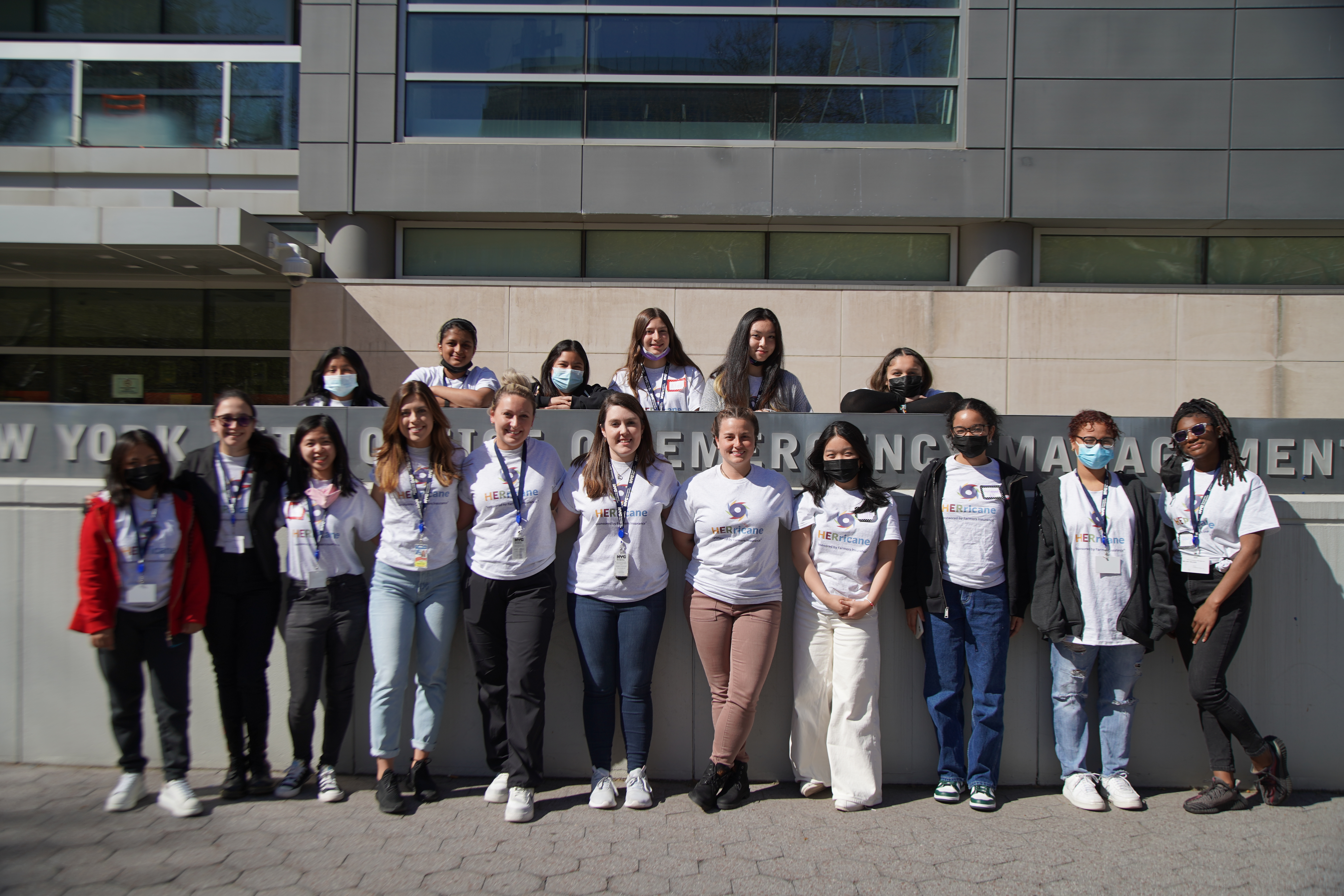 A photo of the inaugural HERricane NYC program class standing in front of NYC Emergency Management headquarters.