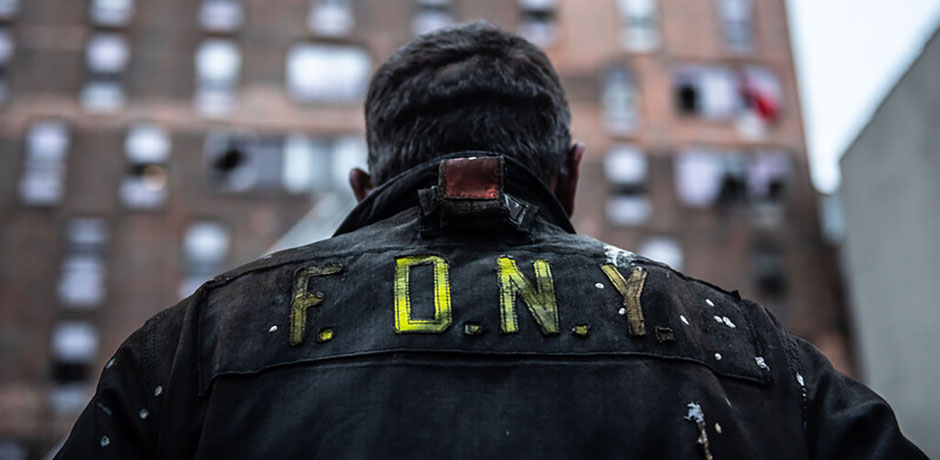 Photo of a Firefighter's back with FDNY on his jacket.