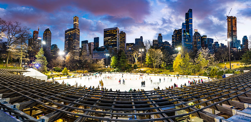 Skaters on ice at Wollman Rink in Central Park at dusk
