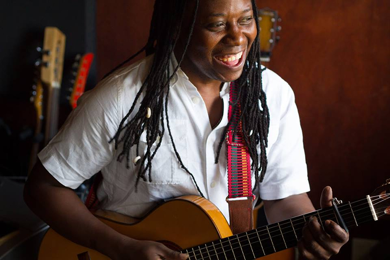 Honduran singer with dreads playing a guitar and singing