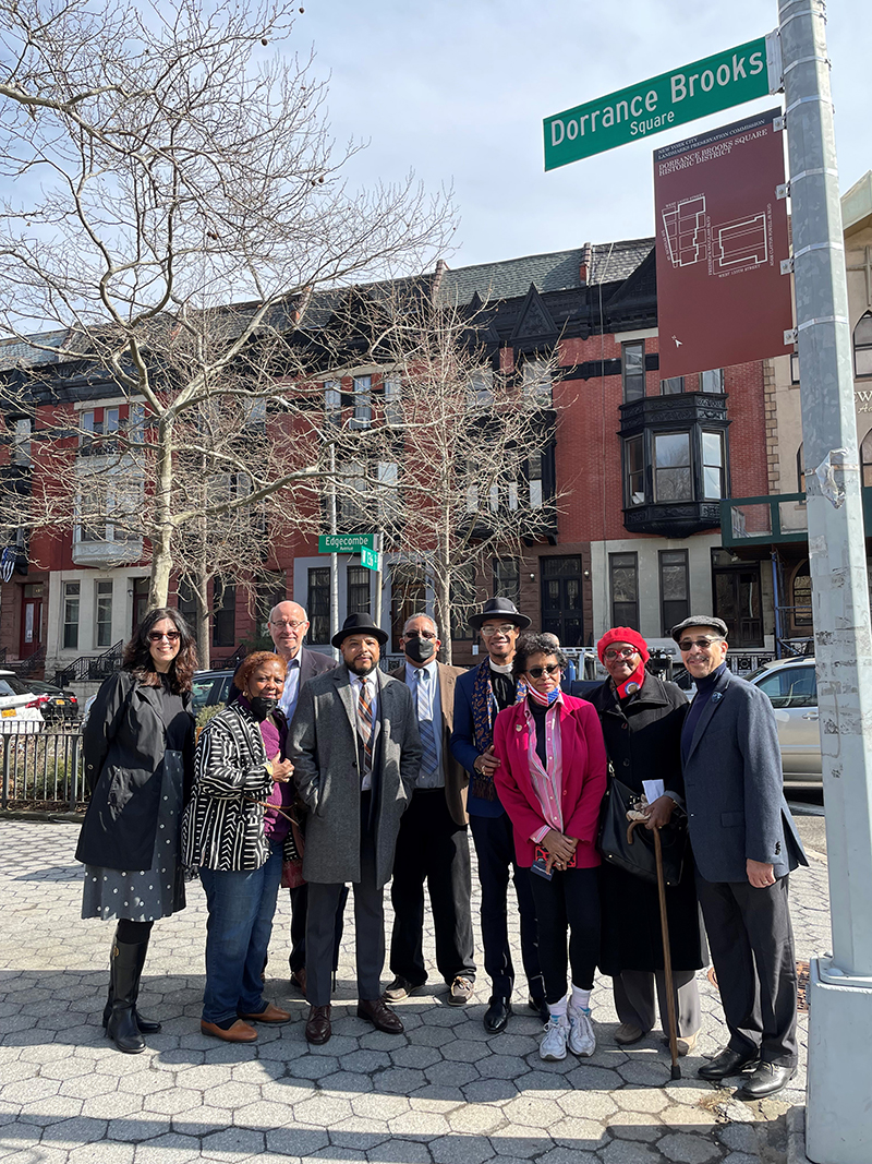 Landmarks Preservation Commission Chair Sarah Carroll (left) joined by New York Landmarks Preservation Foundation Board Member Richard Farley, Community Board 10 District Manager Shatic Mitchell, Keith Taylor, president of the Dorrance Brooks Property Owners and Residents Association, and members of the community, stand below the new Dorrance Brooks Square Historic District marker sign.