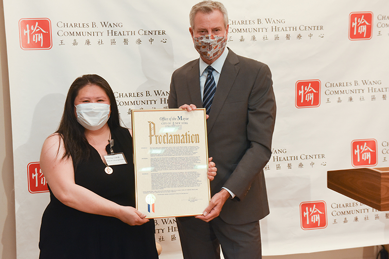 Jiming Liang, Chairperson of the Board of Directors at the Charles B. Wang Community Health Center, and Mayor Bill de Blasio with the proclamation in hand