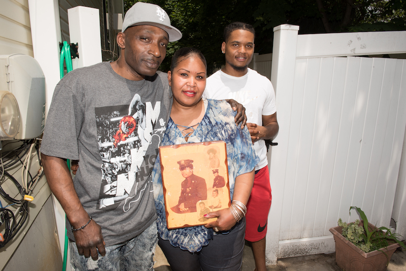 Present day picture of Officer Foster's children holding an old portrait of him