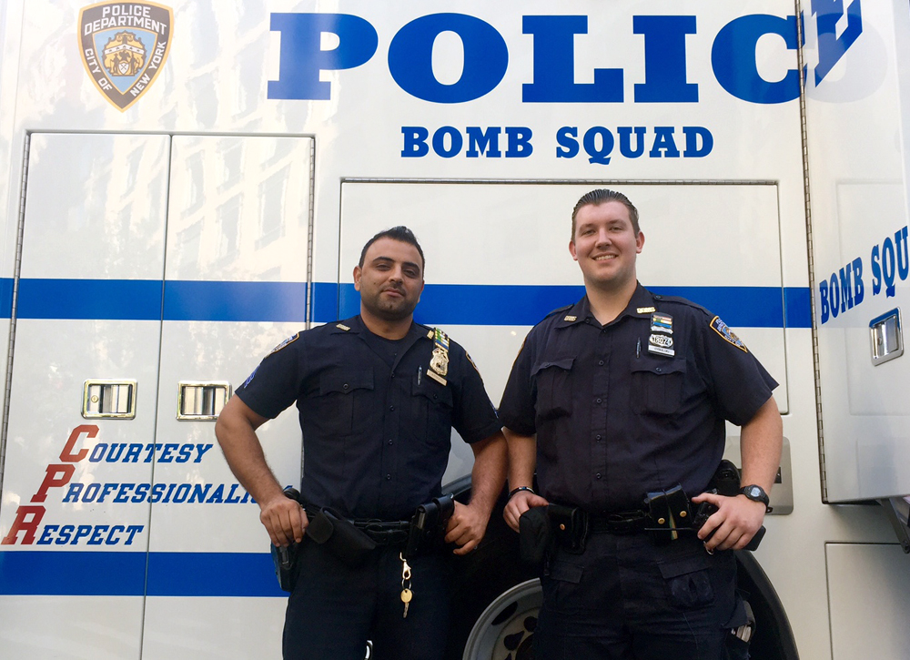 Without hesitation, two NYPD cops selflessly moved what they thought was an explosive device away from thousands of people in Times Square after a device was thrown into their vehicle
