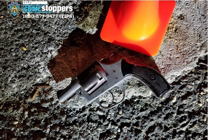 Recovered .32 caliber pistol on asphalt near traffic cone