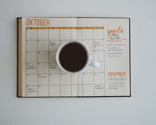 Calendar view of October with a coffee cup ontop of the calendar