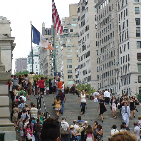 Crowd of people walking up steps to a building