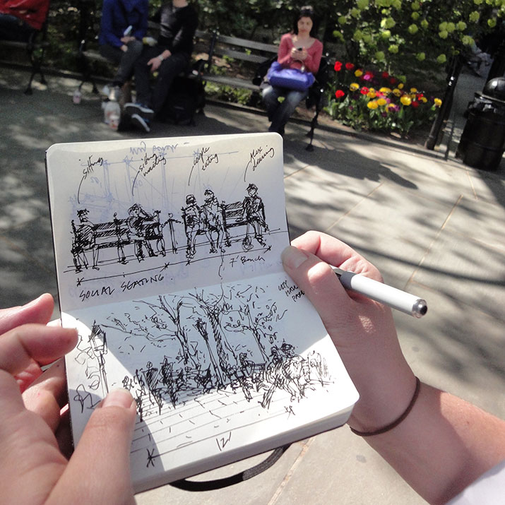 Person sketching their surroundings at a park