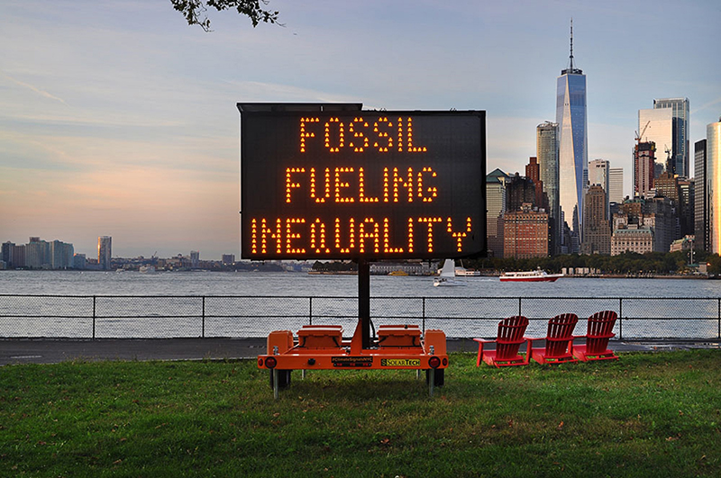 Digital sign in NYC waterfront reading 'Fossil Fueling Inequality'