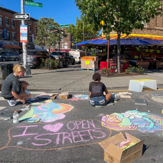 An Open Street decorated with chalk drawings. One of the drawings says “I Heart Open Streets”