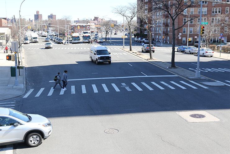 Two pedestrians cross Cropsey Avenue at 24th Avenue before any changes.