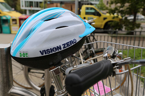 Vision Zero helmet resting atop bicycle handlebars