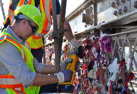 DOT crew working on removing “love locks” on the Brooklyn Bridge.