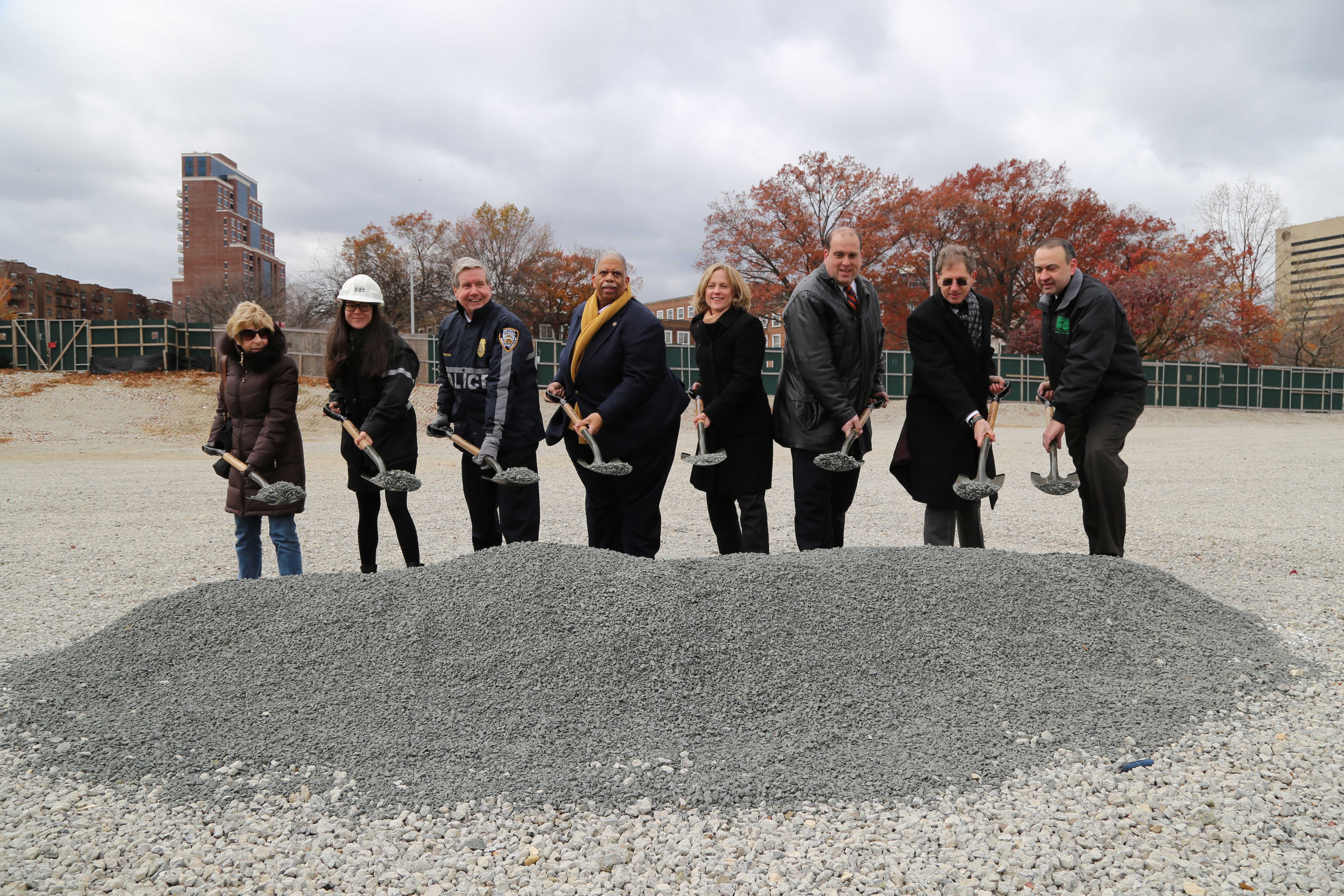 City representatives hold ceremonial shovels of gravel